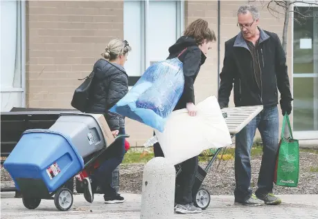  ?? DAN JANISSE ?? A St. Clair College student moves out of the main campus residence on Wednesday with the help of family members.