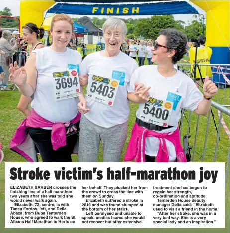  ??  ?? ELIZABETH BARBER crosses the finishing line of a half marathon two years after she was told she would never walk again.
Elizabeth, 72, centre, is with Timea Fordos, left, and Delia Abaza, from Bupa Tenterden House, who agreed to walk the St Albans...