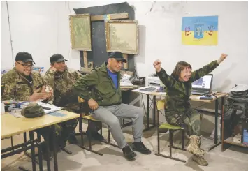  ?? REUTERS ?? Ukrainian service members near Kyiv celebrate band Kalush Orchestra's win in the Eurovision Song Contest, broadcast from Turin, Italy, on Saturday.