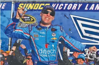  ??  ?? Kevin Harvick celebrates in victory lane Sunday after winning the NASCAR Sprint Cup Series race at New Hampshire Motor Speedway. He pulled away on a late restart to make Matt Kenseth second.