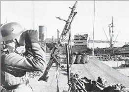  ?? De Agostini Picture Library via Biblioteca Ambrosiana ?? A GERMAN machine gunner offers protective cover for German troops landing in the port of Oslo, Norway, on April 28, 1940.