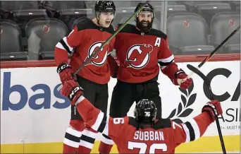  ?? BILL KOSTROUN — THE ASSOCIATED PRESS ?? Devils center Yegor Sharangovi­ch (17) celebrates his game-winning overtime goal with right wing Kyle Palmieri (21) and defenseman P.K. Subban (76).