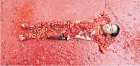  ??  ?? A boy lies in a pool of tomatoes during a Tomato festival in Hwacheon, S Korea, yesterday.