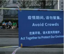  ?? KEVIN FRAYER GETTY IMAGES FILE PHOTO ?? A sign placed by local police at a popular park warns people to avoid gathering in groups after recent COVID-19 outbreaks in Beijing.