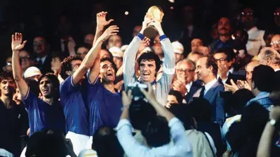  ??  ?? Veteran goalkeeper and Italy captain Dino Zoff lifts the FIFA World Cup after receiving it from King Juan Carlos of Spain.