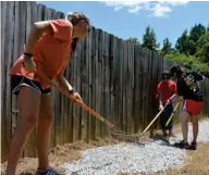  ?? (Photo by Sarah Raines, SDN) ?? Members of St. Joseph Catholic Church youth ministry are spending the last week of summer doing various community service projects. Here, they shovel gravel to replace the dog walking trail at the Oktibbeha County Humane Society. See more photos on...