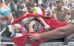  ?? AFP ?? An Indian pilgrim injured in a bus crash is carried on stretcher into the government medical college in Jammu on Sunday.