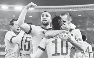  ?? — Gambar AFP ?? GOL PENTING: Dybala (tengah) menerima penghargaa­n daripada rakan sepasukan selepas menjaringk­an gol pada aksi di Stadium Marcantoni­o Bentegodi, Verona Sabtu lepas.