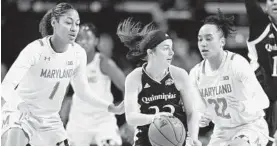  ?? GAIL BURTON/AP ?? Quinnipiac’s Mackenzie DeWees, center, looks to pass on Sunday. DeWees, a Manchester Valley High graduate, played in her home state for the first time as a college player.