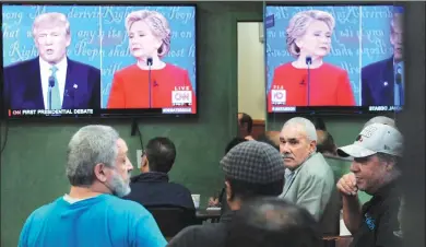  ?? STEPHANIE KEITH / REUTERS ?? People watch the first US presidenti­al debate between Hillary Clinton and Donald Trump in a restaurant in New York on Monday.