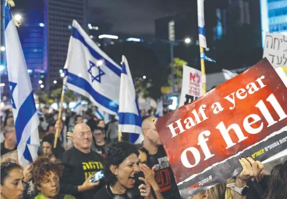  ?? ?? Relatives and supporters of Israeli hostages held in Gaza protest in Tel Aviv as the war in Gaza hits its six-month anniversar­y. Picture: Jack Guez / AFP