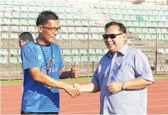  ??  ?? NEW LEADERS... Jelius (left) and Juil shake hands as the former conducts his first team training session with the Sabah senior team at the Likas Stadium yesterday.