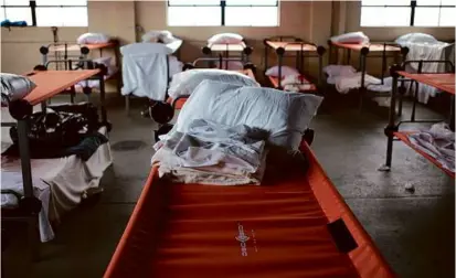  ?? JONATHAN WIGGS/GLOBE STAFF ?? Overflow cots fill part of a thrift store operated by the Lifebridge homeless shelter in Salem, which is seeing unpreceden­ted demand from adults in need of somewhere to sleep.