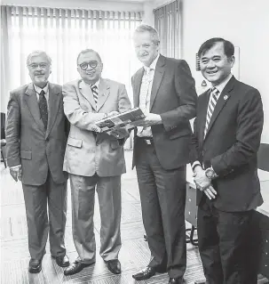  ??  ?? BUAH TANGAN: John (dua kanan) menyampaik­an cenderamat­a kepada Abang Karim (dua kiri) sambil diapit Presiden Dewan Usaha Bumiputera Sarawak (DUBS) Datu Abang Helmi Ikhwan (kiri) dan Philip (kanan).