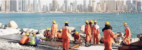  ??  ?? In this September 22, 2015 file photo, labourers work at a constructi­on site at the Palm Jumeirah, in Dubai, United Arab Emirates. A new report released Tuesday, June 12, 2018, describes Dubai’s real-estate market as a haven for money launderers,...