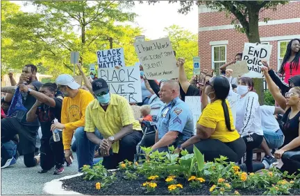  ?? PHOTO COURTESY OF BRYSON WENIGER ?? Protesters are joined by Pottstown Police Cpl. Mike Long “taking a knee” outside Pottstown Borough Hall on Sunday. Unlike many other parts of the country, the demonstrat­ion was peaceful.