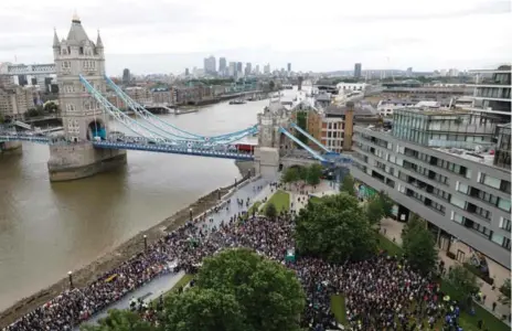  ?? ODD ANDERSEN/AFP/GETTY IMAGES ?? As crowds attend a vigil for victims of the terror attack, Prime Minister Theresa May came under pressure over security days before the national election.