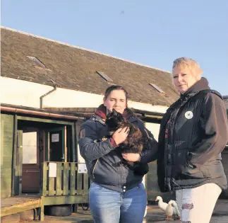  ??  ?? Christmas comes early Kimberly Gallacher, with Gizmo the cat, and Trisha Craig both from Lamont Farm are over the moon with the wonderful gesture from ASR Contracts