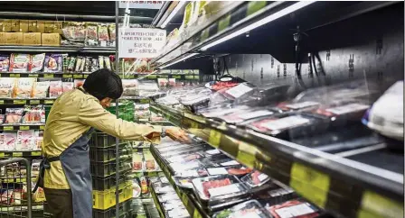  ?? — AFP ?? Major market: A worker clears packs of imported meat from Brazil off the shelves of a supermarke­t in Hong Kong. China, including Hong Kong, is the biggest export market for Brazilian meat, buying about a third of the US$5.5bil of beef shipped from Latin America’s largest economy last year.