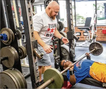  ?? ?? Dave Githutu, a Milton High School weightlift­er, trains Tuesday at Roswell Barbell with coach Josh Porter. The 18-year-old is competing in the British Weight Lifting Championsh­ips in September.