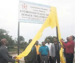  ?? PHOTO BY BRYAN MILLER ?? Minister of Health Dr Christophe­r Tufton (right) being assisted by Minister of Science, Energy and Technology Dr Andrew Wheatley (left) to unveil the sign to mark the official handing over of the rehabilita­ted and upgraded sewage treatment facility at...