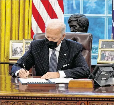  ?? PHOTO: REUTERS/KEVIN LAMARQUE ?? New deal: US President Joe Biden signs an executive order in the Oval Office yesterday.