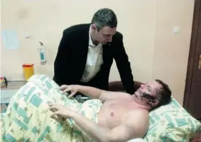  ?? THE ASSOCIATED PRESS ?? Ukrainian opposition leader Vitali Klitschko speaks with Dmytro Bulatov in a Kyiv hospital, where Bulatov was taken after being found dumped in a forest with severe injuries.