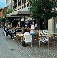  ??  ?? A distanza I tavolini occupati al caffè San Marco