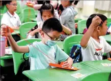  ?? LIU YING / XINHUA ?? Children make handicraft­s at a summer day care class in Shanghai on Monday, when the city started its summer day care service for tens of thousands of primary school students.