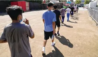  ?? Marcio Jose Sanchez / Associated Press ?? Migrant children walk together after a game of soccer July 2 at an emergency shelter in California. These unlicensed sites were supposed to be temporary, but they have been operating for months.