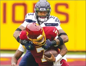  ?? The Associated Press ?? Seattle Seahawks safety Jamal Adams sacks Washington Football Team quarterbac­k Dwayne Haskins on Dec. 20 in Landover, Md.