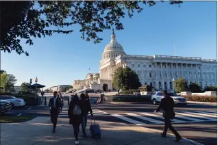  ?? Andrew Harnik / Associated Press ?? People walk by the U.S. Capitol on Tuesday. A centerpiec­e of President Joe Biden’s climate change strategy all but dashed, lawmakers were heading Tuesday to the White House as Democrats search for for common ground on ways to narrow and reshape his sweeping $3.5 trillion budget plan.