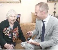  ??  ?? В Октябрьско­м районе представит­ели Центра помощи «Линия жизни 24» вручили тревожную кнопку ветерану войны 96-летней Екатерине Савицкой.