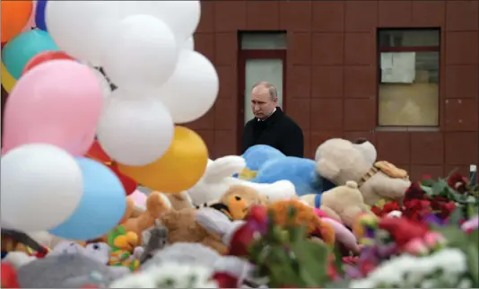  ?? PICTURE: ALEXEI DRUZHININ/SPUTNIK/ KREMLIN POOL/ AP) ?? Russian President Vladimir Putin lays flowers by a floral tribute for the victims of a fire in a multi-story shopping centre in the Siberian city of Kemerovo, about 3000km east of Moscow, Russia, yesterday. Russian officials say that fire escapes were...