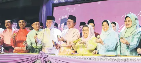  ??  ?? Abang Johari (front, fourth right) holds up a piece of ‘lemang’ together with (front, from right) Fatimah, Ruziah, Juma’ani, Awang Tengah, Fadillah, Wan Junaidi, and Dr Hazland. – Photo by Agnes Tugong