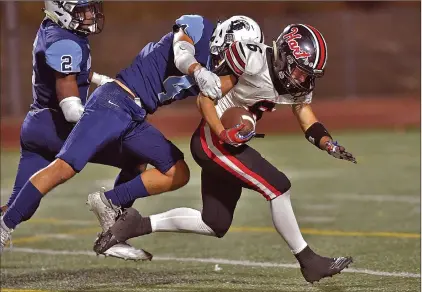  ?? Dan Watson/The Signal ?? (Above) Hart’s Taden Littleford (6) is taken down by Saugus defender Cade Gallagher (4). The run set up Hart’s second touchdown in the first quarter at College of the Canyons on Friday.