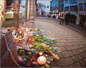  ?? PIC EPA ?? Flowers and candles are left where a person was killed in the Christmas Market shooting in Strasbourg, France, yesterday.