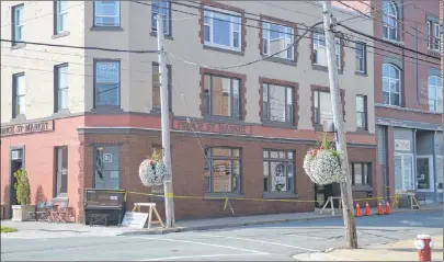  ?? NIKKI SULLIVAN/CAPE BRETON POST ?? The sidewalk that goes past the Prince Street Market was blocked by police tape on Wednesday and the doors to the entrance upstairs was closed, with the windows covered so people could not see in. This is the location of the alleged homicide of Cape...