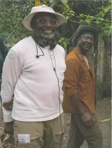  ?? DAVID LEE/NETFLIX ?? Director Spike Lee, left, pauses on the set of Da 5 Bloods with one of its stars, Clarke Peters. The film is streaming on Netflix.