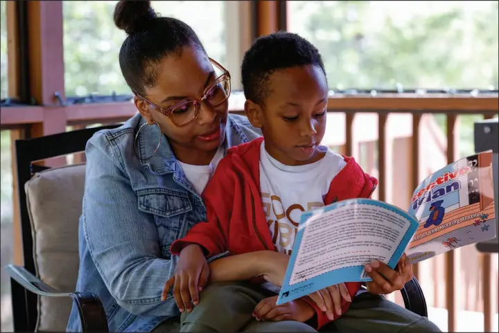  ?? BUTCH DILL / ASSOCIATED PRESS ?? Adriane Burnett reads to her son Karter Robinson on April 14 in Birmingham, Ala. Women’s participat­ion in the American workforce has reached a high point, but challenges around child care are holding back many working-class parents.