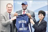  ?? Arnold Gold / Hearst Connecticu­t Media ?? Scott Burrell, center, was named the new Southern Connecticu­t State University men’s basketball coach in 2015. At left is athletic director Jay Moran and, at right, is Southern Connecticu­t State University President Mary Papazian.