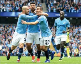  ?? — AFP ?? Manchester City’s Sergio Aguero ( second from left) celebrates with team mates after scoring against Huddersfie­ld in their English Premier League match at the Etihad Stadium in Manchester on Sunday. The hosts won 6- 1.