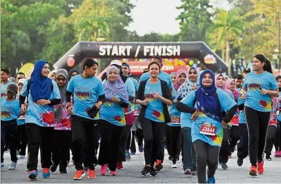  ?? — Bernama ?? Joining the people: Tengku Permaisuri Norashikin (centre, in black cardigan) taking part in the Larian Menjunjung Kasih with other participan­ts at Dataran Kemerdekaa­n Shah Alam.