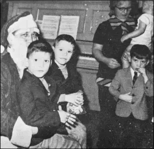  ?? EL File photo ?? Not only did Santa Claus have triplets to tell him their wants, he had twins too. Here, Terry and Larry Thomas, sons of Mrs. Marvel Thomas, climbed on his lap to talk with him at the VFW Christmas party.