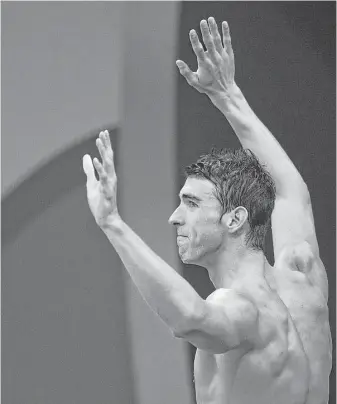  ?? Martin Bureau / AFP / Getty Images ?? Michael Phelps celebrates after the U.S. men’s swimming team captured the 400-meter medley relay Saturday night. Phelps swam the butterfly leg, taking a lead the team did not relinquish.