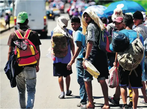  ?? PEDRO PARDO / AFP / GETTY IMAGES ?? Honduran migrants heading in a caravan to the U.S. walk alongside a road in Tapachula, Mexico on Monday.