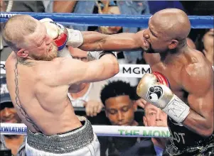  ?? "1 1)050 ?? Floyd Mayweather Jr. hits Conor McGregor in a super welterweig­ht boxing match Saturday, in Las Vegas.