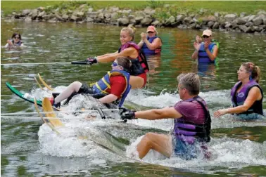  ?? STAFF PHOTO BY DOUG STRICKLAND ?? Andrew Rich takes off on a water ski with two flanking skiers during the Sports, Arts & Recreation of Chattanoog­a organizati­on’s annual water sports day at First Lutheran Church Camp last Saturday in Soddy-Daisy,