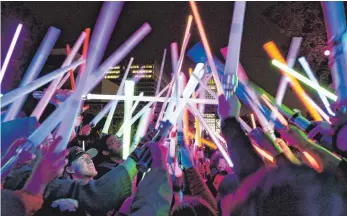  ?? FOTO: DPA ?? „ Star Wars“-Fans bei einem Treffen der „Glow Battle Tour“, einem US- weiten Fan- Event in Los Angeles: Diese Plastik- Lichtschwe­rter haben wohl weniger Energie als ihre Filmvorbil­der.