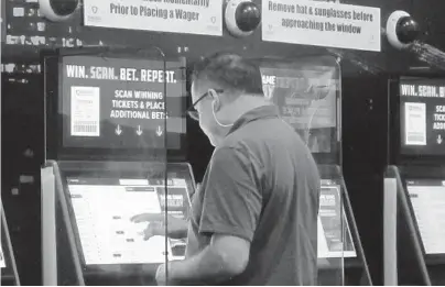  ?? WAYNE PARRY/AP ?? A gambler places a bet Aug. 30 at the FanDuel sportsbook in East Rutherford, New Jersey. The American Gaming Associatio­n says 45.2 million Americans plan to bet on NFL games this season, up 36% from last year.